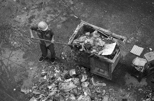 Team loading rubbish from a terraced house on a busy street